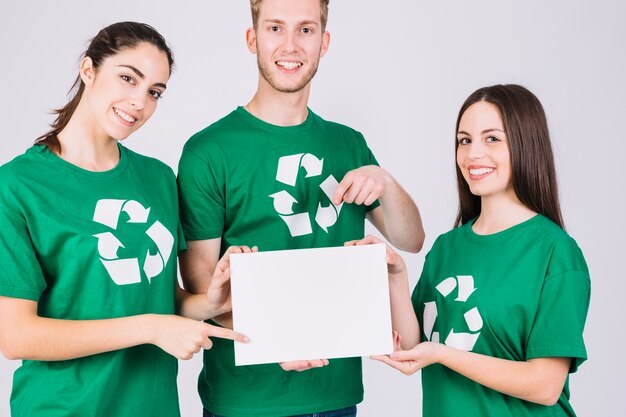 Gruppo di amici felici tenendo il cartello bianco