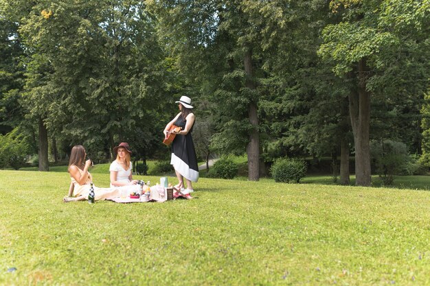 Gruppo di amici femminili godendo sul picnic nel parco