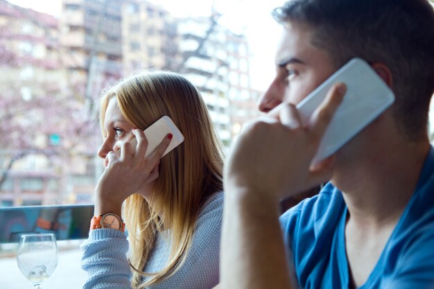 Gruppo di amici utilizzando il telefono cellulare in caffè.