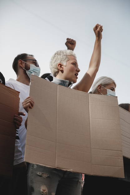 Gruppo di attivisti che danno slogan in una manifestazione. Uomini e donne che marciano insieme in una protesta