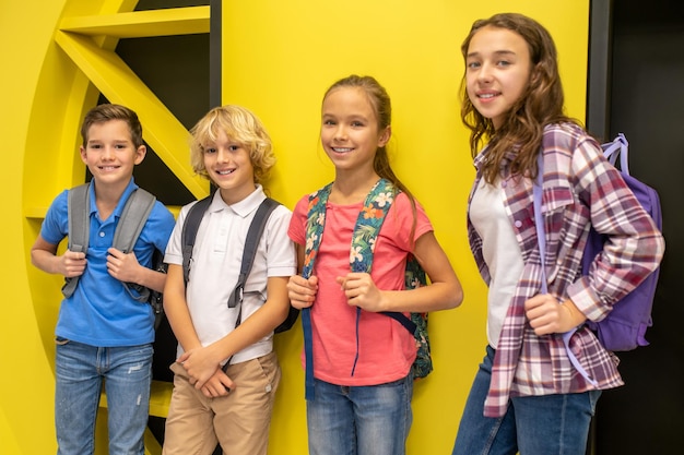 Gruppo di bambini sorridenti con zaini in posa per la fotocamera