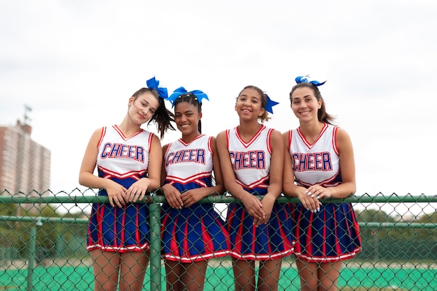 Gruppo di cheerleader graziose adolescenti in uniforme carina