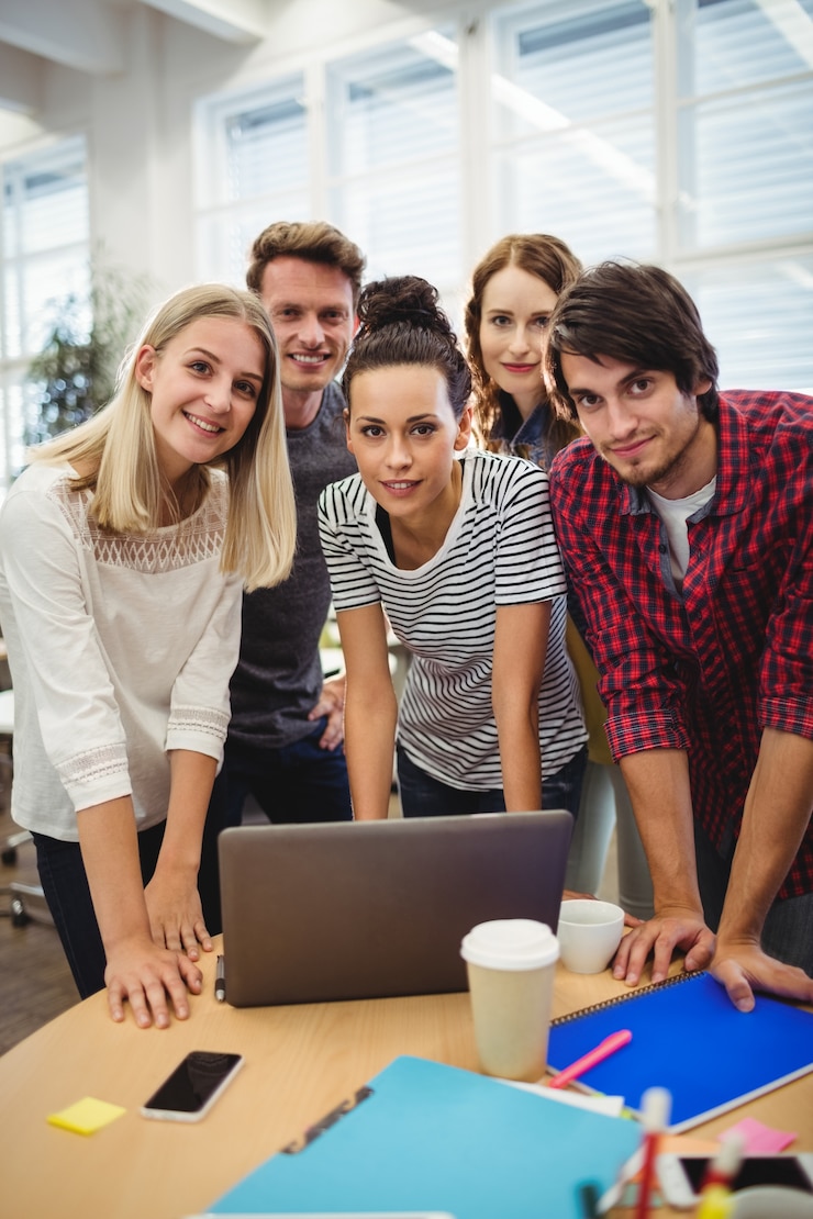 Foto gratuito gruppo di dirigenti aziendali sorridere alla telecamera a loro scrivania