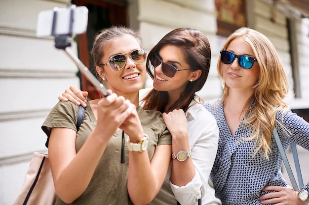 Gruppo di donne alla moda che godono della città e che scatta una foto