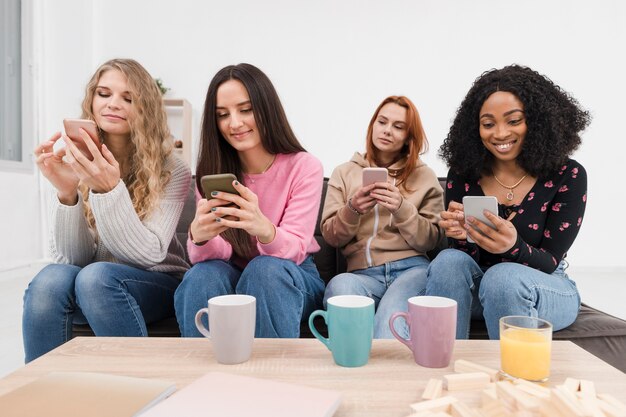 Gruppo di donne che trascorrono del tempo insieme sui loro telefoni