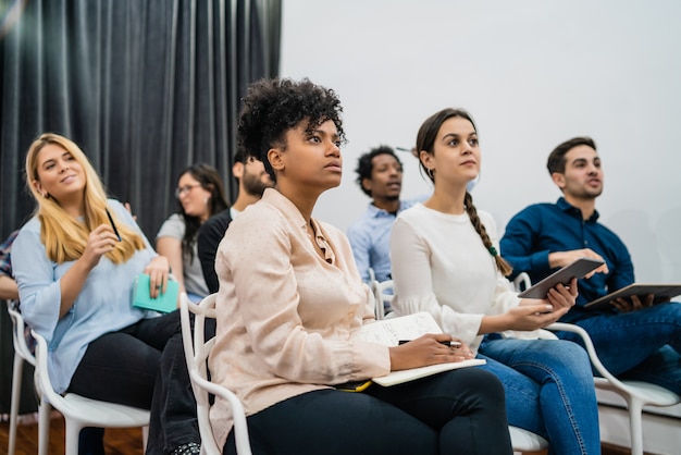 Gruppo di gente di affari creativa che ascolta il collega che si rivolge alla riunione dell'ufficio. Concetto di business e brainstorming.