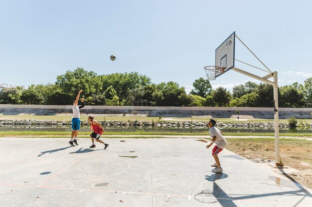 Gruppo di giocatori che giocano a basket all&#39;aperto corte