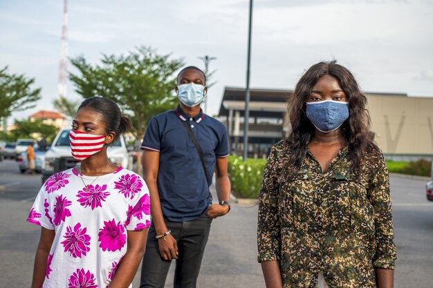 Gruppo di giovani africani con maschere in piedi in strada