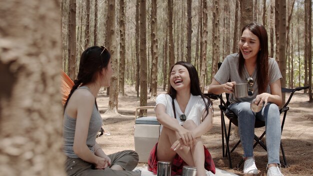 Gruppo di giovani amici asiatici campeggio o picnic insieme nella foresta