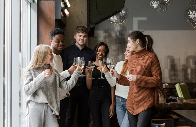 Gruppo di giovani amici che mangiano vino insieme