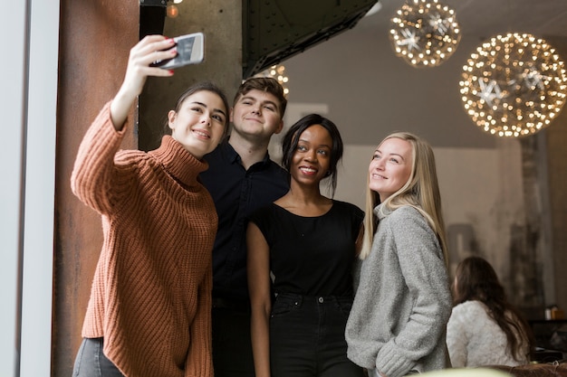 Gruppo di giovani amici che prendono insieme un selfie