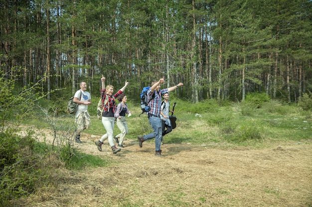 Gruppo di giovani amici felici divertendosi nella natura in una soleggiata giornata estiva