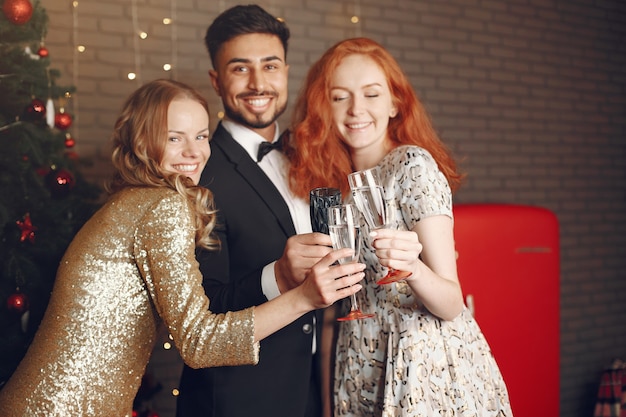 Gruppo di giovani che celebrano il nuovo anno. Donne con uomo indiano.