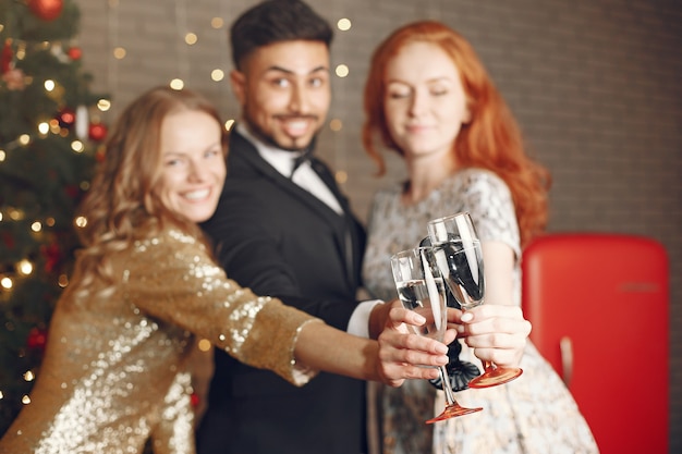 Gruppo di giovani che celebrano il nuovo anno. Donne con uomo indiano.