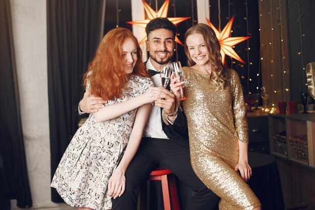 Gruppo di giovani che celebrano il nuovo anno. Donne con uomo indiano.