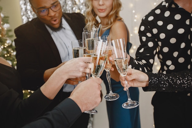 Gruppo di giovani che celebrano il nuovo anno. Gli amici bevono champagne.