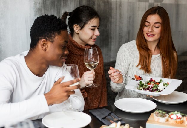 Gruppo di giovani che godono insieme della cena