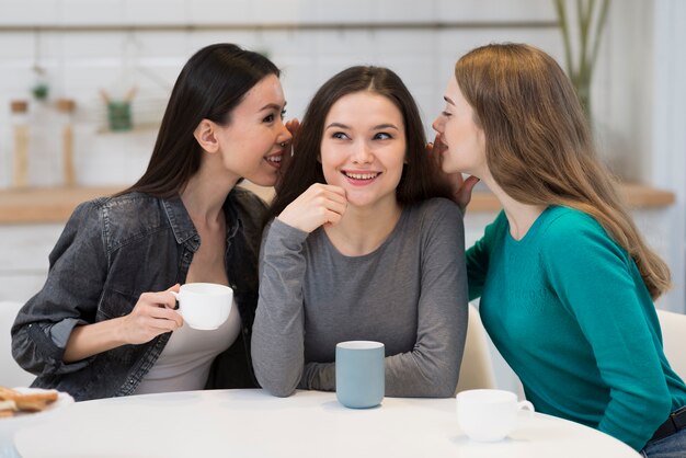 Gruppo di giovani donne che spettegolano insieme