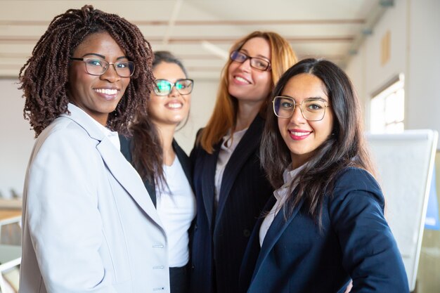 Gruppo di giovani donne di affari sicure che esaminano macchina fotografica