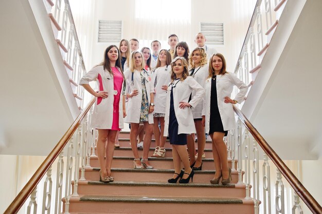 Gruppo di giovani medici in camice bianco in posa in ospedale