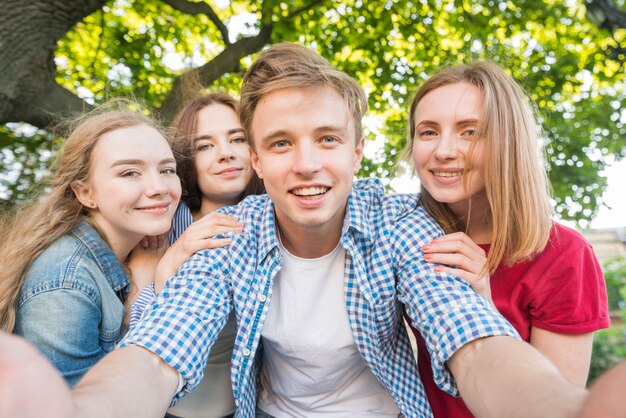 Gruppo di giovani studenti che assumono selfie