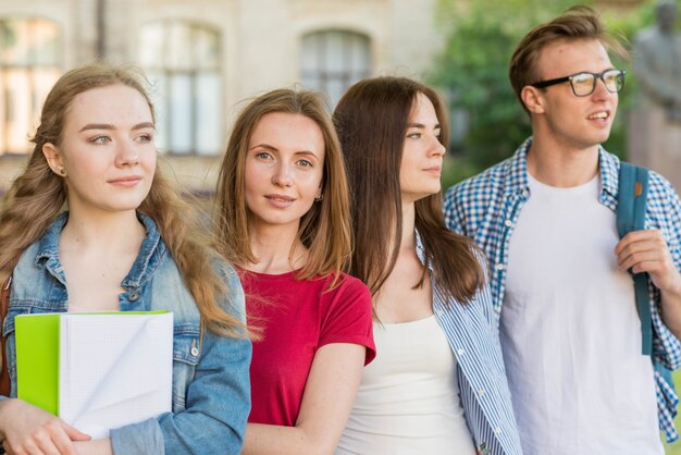 Gruppo di giovani studenti di fronte all&#39;edificio scolastico