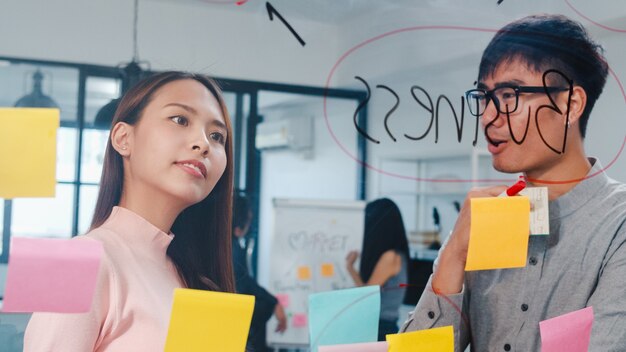 Gruppo di giovani uomini d'affari e donne d'affari che fanno brainstorming di idee che lavorano insieme condividendo dati