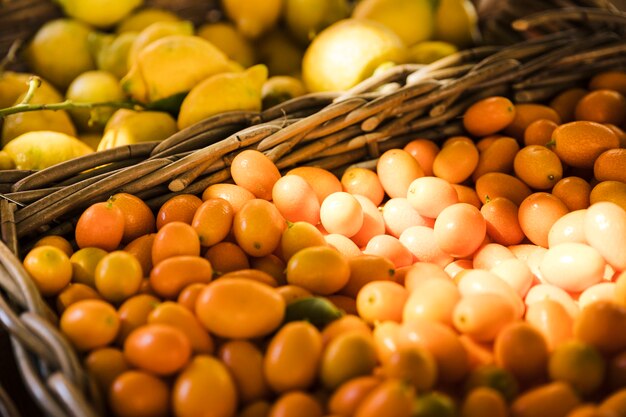 Gruppo di kumquat in cesto di vimini al mercato della frutta