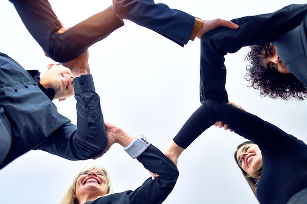 Gruppo di lavoratori aziendali in piedi con le mani insieme in ufficio