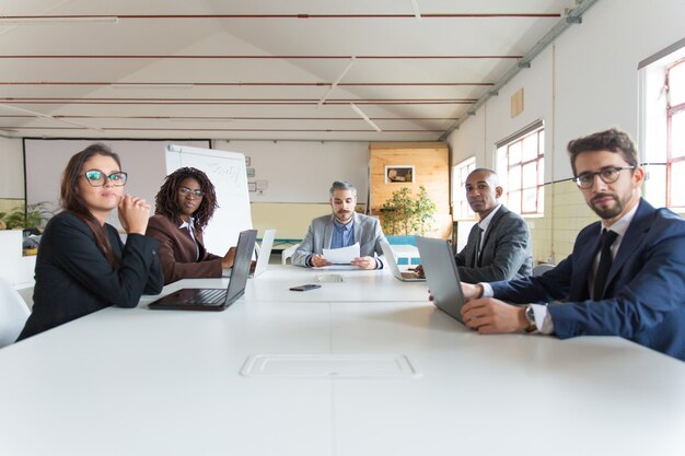 Gruppo di manager seri durante il briefing mattutino