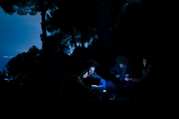 Gruppo di notte delle viandanti delle giovani coppie che si accampa in montagne