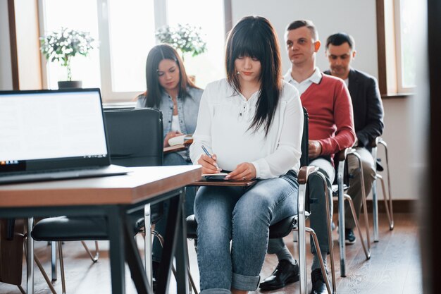 Gruppo di persone alla conferenza di lavoro in aula moderna durante il giorno