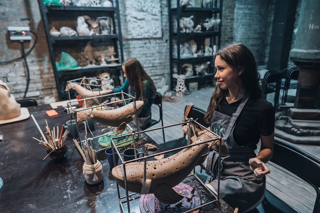 Gruppo di persone che godono del lavoro preferito in officina. Le persone lavorano con attenzione sulle balene di ceramica