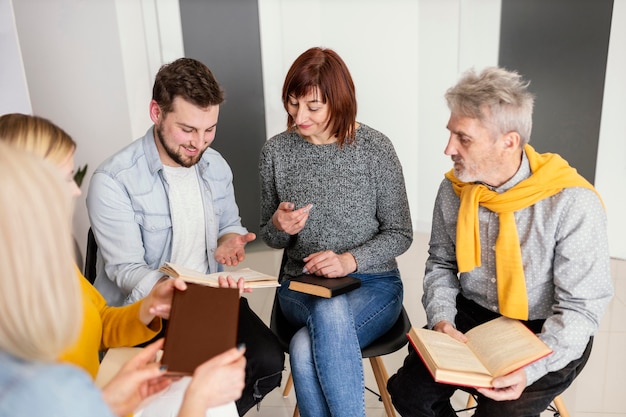 Gruppo di persone che leggono libri alla sessione di terapia