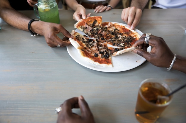 Gruppo di persone che mangiano pizza vicino