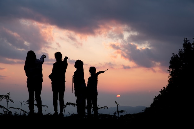 Gruppo di persone felici che giocano al tramonto estivo in natura