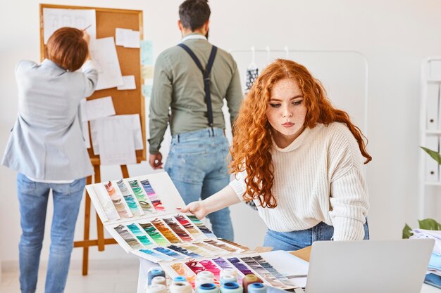 Gruppo di stilisti che lavorano in atelier con tavolozza dei colori e tavola delle idee