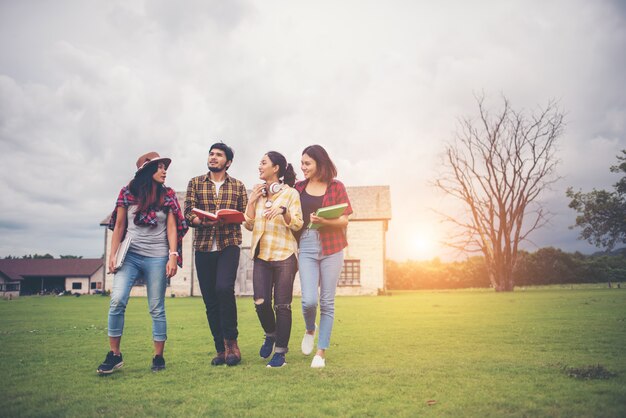 Gruppo di studenti a piedi attraverso il parco dopo le lezioni. Divertiti a parlare insieme.