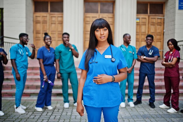 Gruppo di studenti di medicina africani posati all'aperto contro la porta dell'università