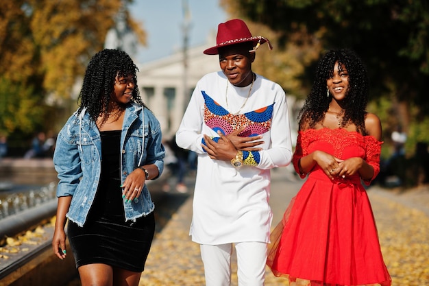 Gruppo di tre amici alla moda afro-francesi alla moda posti al giorno d'autunno Modello uomo africano nero con due womans dalla pelle scura