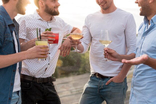 Gruppo di uomini che discutono ad una festa in terrazza