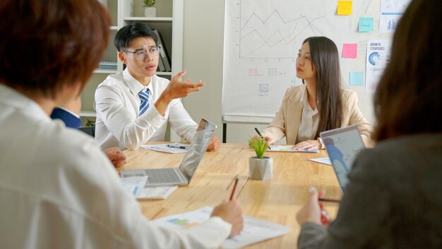 Gruppo di uomini d'affari asiatici che discutono della strategia di idee per riunioni di brainstorming aziendale in ufficio