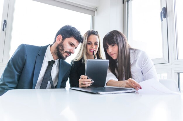 Gruppo di uomini d&#39;affari guardando la tavoletta digitale in ufficio