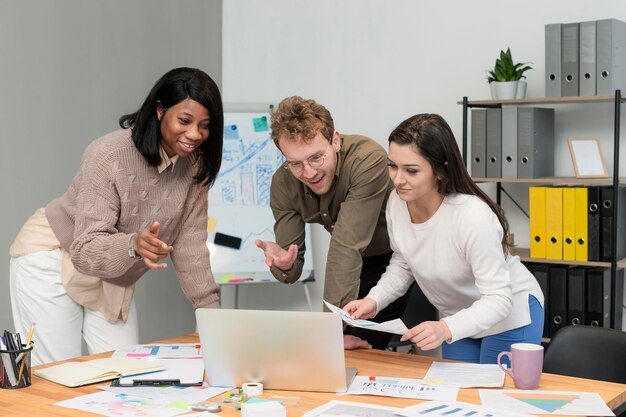 Gruppo di vista frontale di giovani che collaborano al lavoro