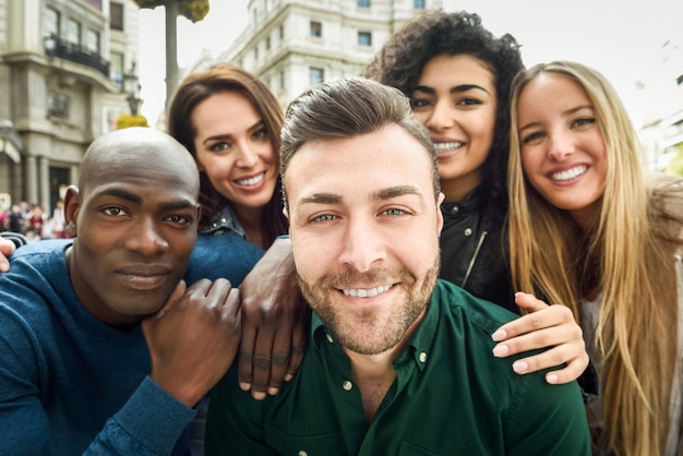 Gruppo multirazziale di giovani che prendono selfie