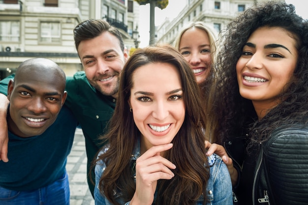 Gruppo multirazziale di giovani che prendono selfie