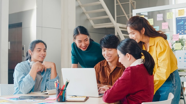 Gruppo multirazziale di giovani creativi in abbigliamento casual intelligente che discute di idee per riunioni di brainstorming di affari progetto di progettazione di software applicativo mobile in ufficio moderno. Concetto di lavoro di squadra del collega.