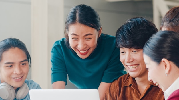 Gruppo multirazziale di giovani creativi in abbigliamento casual intelligente che discute di idee per riunioni di brainstorming di affari progetto di progettazione di software applicativo mobile in ufficio moderno. Concetto di lavoro di squadra del collega.