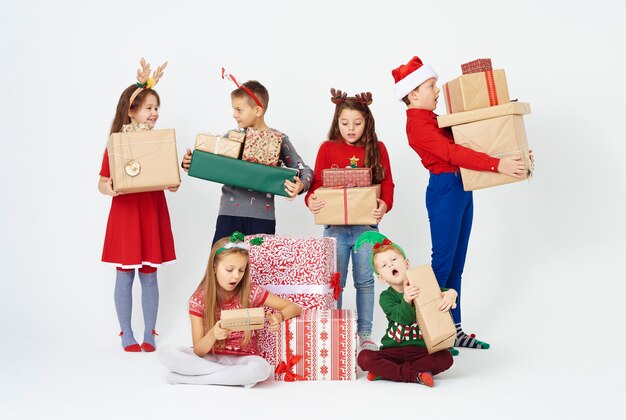 Gruppo sorpreso di bambini che guardano il regalo di Natale