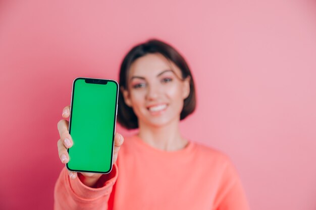 Guarda questo cellulare! La donna felice soddisfatta indica con il dito indice allo schermo vuoto, mostra il dispositivo moderno, emozioni sorprese felici.